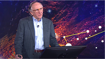 CEO Jack Dangermond standing at a podium in front of a blue and pink background 